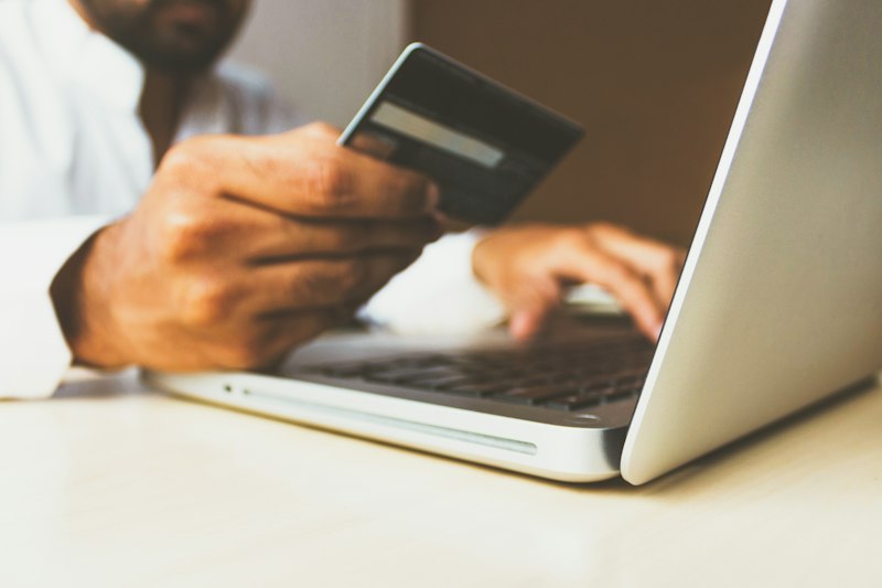 Customer completing online store checkout and credit card payment on laptop