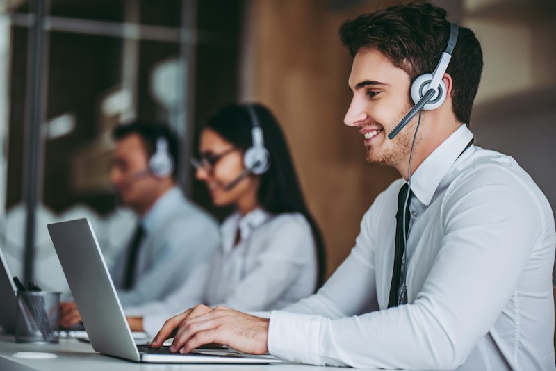 Customer support specialist with headset collaborating at computer